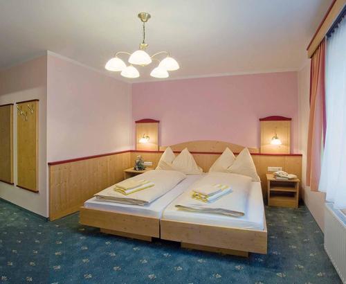 Un dormitorio con una cama grande y una lámpara de araña. en Gasthof Birgl en Inning