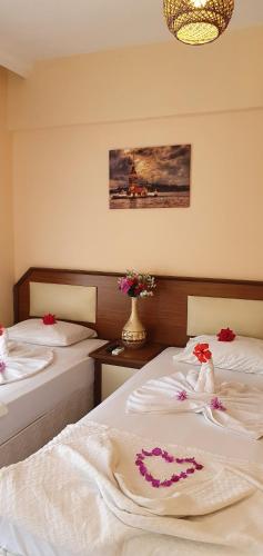 a bedroom with two beds with flowers on them at Palmen Apart Hotel in Alanya
