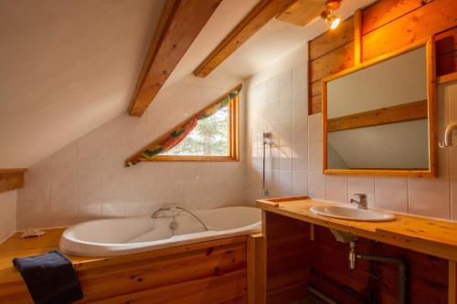 a bathroom with a tub and a sink at L'Elva Hameau des Chazals Nevache Hautes Alpes in Névache