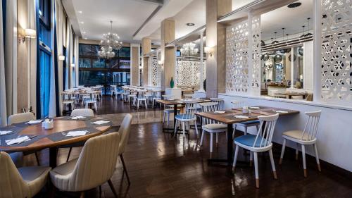 a restaurant with tables and chairs in a room at Pestana D. João II Beach & Golf Resort in Alvor