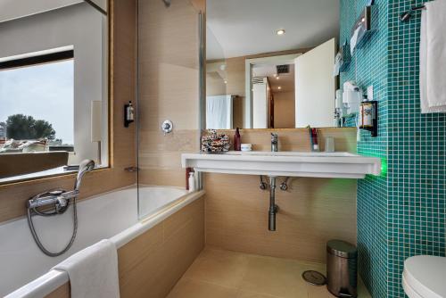 a bathroom with a sink and a tub and a shower at Pestana D. João II Beach & Golf Resort in Alvor