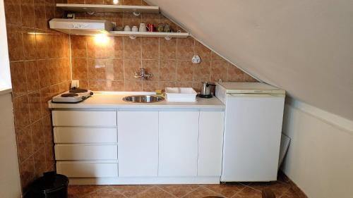 eine kleine Küche mit einem Waschbecken und einer Treppe in der Unterkunft Apartman Trifunović Sokobanja in Sokobanja