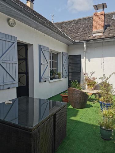 a house with a patio with green grass at Chambres d'hôtes Chez Valérie Garage motos et vélos in Arette