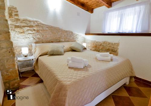 a bedroom with a large bed with towels on it at Charming stone cottage by the sea in Umag