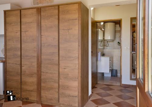 a large wooden closet in a room with a kitchen at Charming stone cottage by the sea in Umag