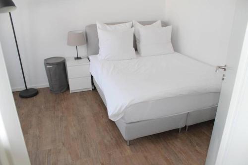 1 dormitorio con 1 cama blanca con sábanas y almohadas blancas en LONDON . CHILLINGHOUSE # 9, 3 Min. vom ICE, NETFLIX, Garten, en Siegburg