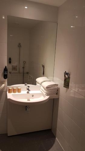 a bathroom with a sink and a large mirror at ibis budget Annemasse Geneve in Annemasse