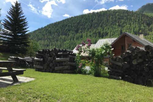 a cabin in the mountains with a stone wall at Le Taquo Hameau des Chazals Nevache Hautes Alpes in Névache