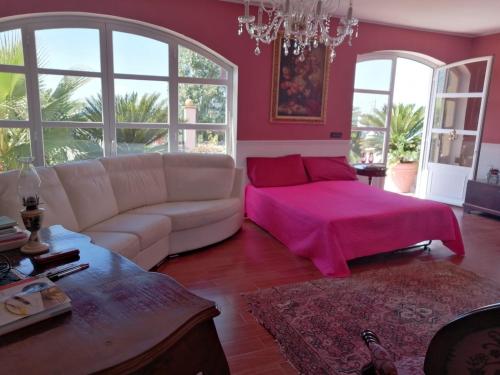 uma sala de estar com um sofá branco e um cobertor rosa em Villa Grace em Patti