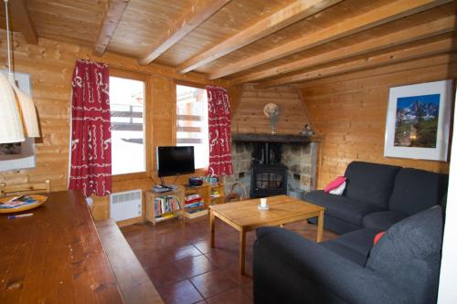 a living room with a couch and a fireplace at Le Baoùba Hameau des Chazals Nevache Hautes Alpes in Névache
