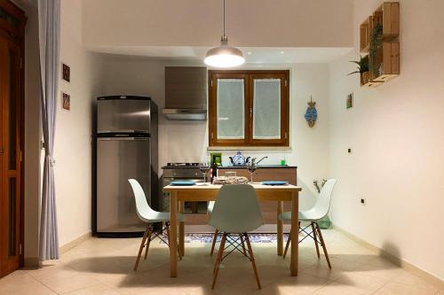 una cucina con tavolo, sedie e frigorifero di La Rotonda - Casa vacanze a Giovinazzo