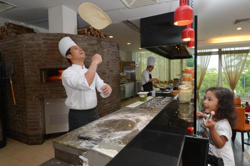 a man and a little girl in a kitchen at Holiday Inn Melaka by IHG in Melaka