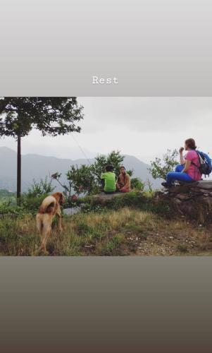 a group of people and a dog on a hill at NamaStay Himalayas, KANATAL in Kanatal