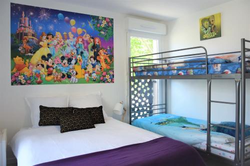 a bedroom with two bunk beds and a painting on the wall at Dream Appartement Paris in Montévrain