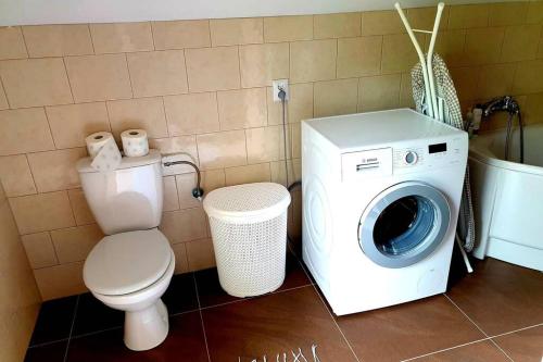 a bathroom with a washing machine and a toilet at Klimatyczna Willa w stylu BOHO in Wysokie Mazowieckie