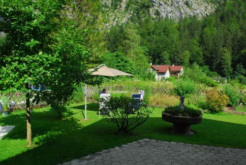 un jardín con sombrilla y sillas y una casa en Ferienwohnung bon WAB, en Hallstatt