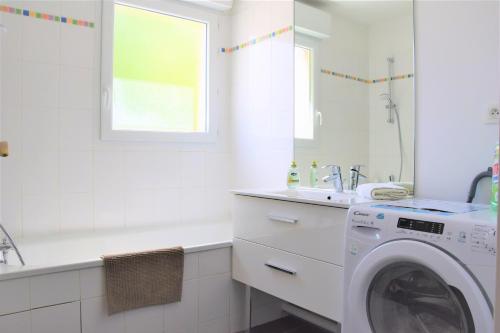 a white bathroom with a washing machine and a sink at Dream Appartement Paris in Montévrain