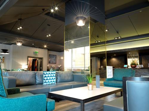 a lobby with blue couches and a coffee table at Crowne Plaza Harrogate, an IHG Hotel in Harrogate