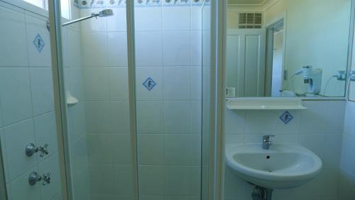 a bathroom with a shower and a sink at Watersedge Motel in Woy Woy