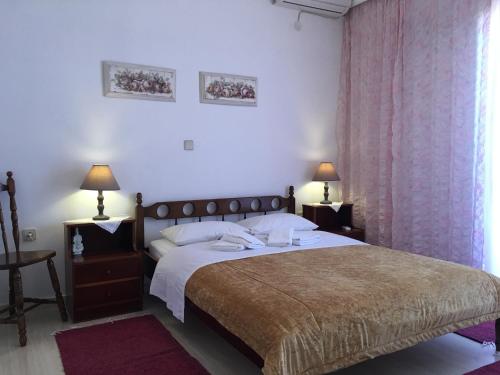 sypialnia z łóżkiem, 2 lampami i oknem w obiekcie Chris Studios & Apartments w mieście Lechaio