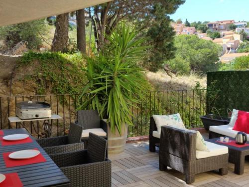 a patio with chairs and tables and a plant at Résidence La Grande Voile in Banyuls-sur-Mer