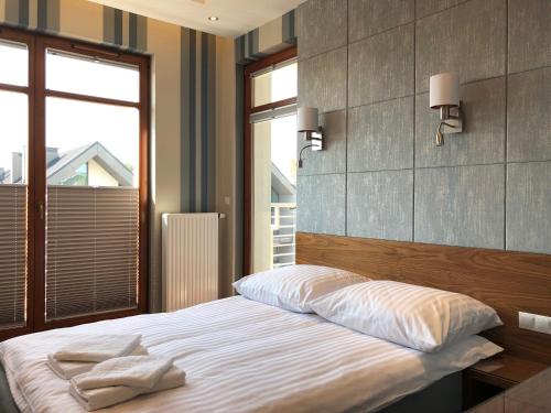 um quarto com uma cama e uma grande janela em Apartament Neptun Park - 100m od plaży em Gdansk