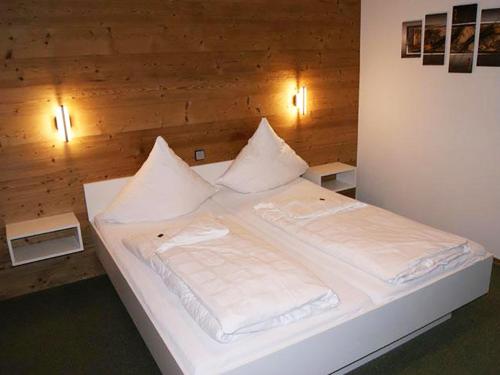 białe łóżko z białą pościelą i poduszkami w obiekcie Pension an der Linde w mieście Bad Birnbach