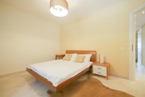 a bedroom with a bed with white sheets and a lamp at Giulia in Verbania