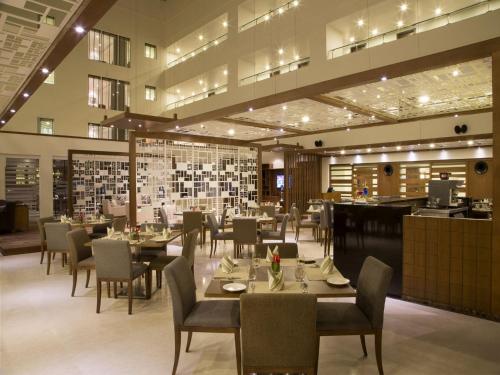 a dining room with tables and chairs in a restaurant at Oakwood Residence Whitefield Bangalore in Bengaluru