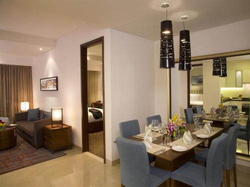 a dining room and living room with a table and chairs at Oakwood Residence Whitefield Bangalore in Bengaluru