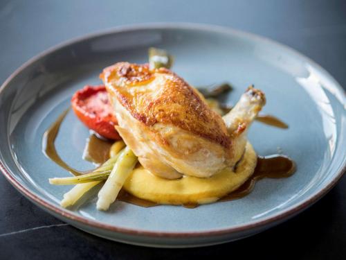 a plate of food with a piece of chicken on pasta at The Sebel Melbourne Moonee Ponds in Melbourne