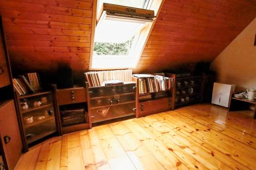 a attic room with a window and a book shelf at Chaloupka Žďárky in Žďárky