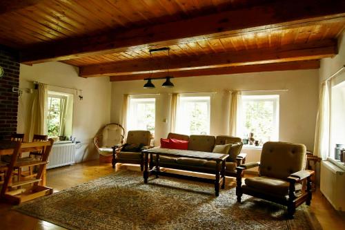a living room with chairs and a table and windows at Chaloupka Žďárky in Žďárky