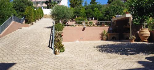 a brick walkway with plants on the side of a building at Onira Boutique in Tolo