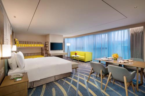 pokój hotelowy z łóżkiem, stołem i krzesłami w obiekcie Holiday Inn & Suites Lanzhou Center, an IHG Hotel w mieście Lanzhou