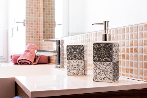 een wastafel in de badkamer met twee zeepdispensers bij Migliarina Cozy Apartment in La Spezia