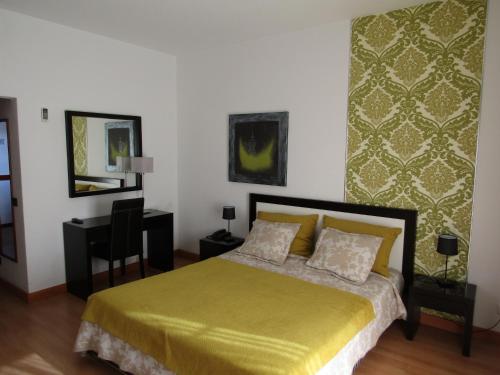 sypialnia z łóżkiem i biurkiem w obiekcie Hotel Caldas Internacional w mieście Caldas da Rainha