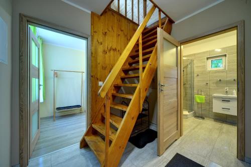 La salle de bains est pourvue d'une douche et d'un escalier en bois. dans l'établissement Pensjonat Olympia, à Przesieka