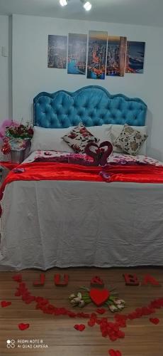a bedroom with a blue bed with red flowers on the floor at Terraço Harmony Flats GRU in Guarulhos