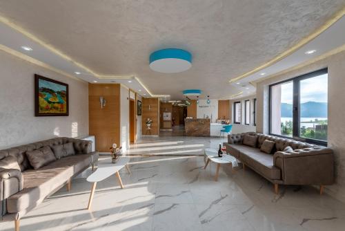 a large living room with couches and a large window at MOBI DICK Family Hotel in Glavatartsi