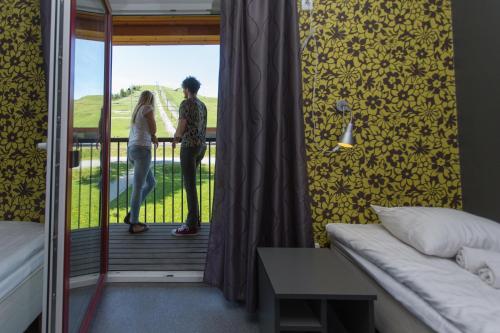 a man and woman standing on the balcony of a room at Tuhamäe Hostel in Kiviõli