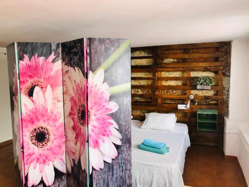 a room with a bed with pink flowers on the wall at Apartamento Valencia in Catarroja