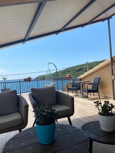 a patio with two chairs and a table with plants at Apartments Boss in Budva