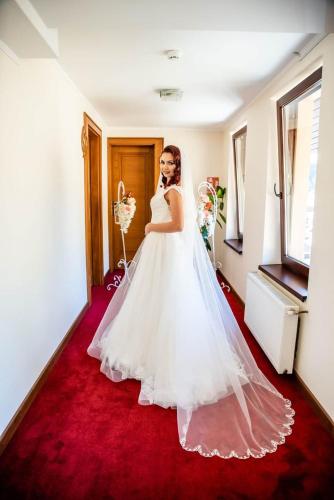 a bride in a wedding dress standing in a room at Hotel Dennis in Mediaş
