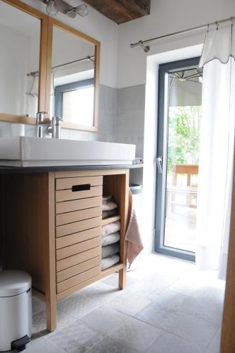 a bathroom with a sink and a large mirror at Le champ Bagnolet in Voussac