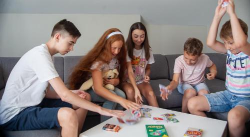 a group of young people playing a game on a table at Biplan Hotel in Daugavpils