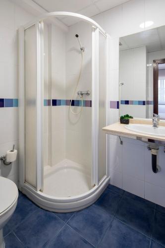 a bathroom with a shower and a toilet and a sink at Pensión Venus in Nigrán