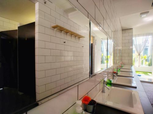 a bathroom with three sinks and a large mirror at Beds In Garden Hostel in Ipoh