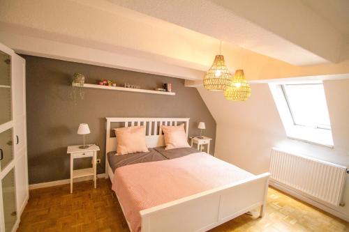 a bedroom with a bed with pink sheets and a window at Main Idyll in Frickenhausen