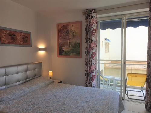 um quarto com uma cama e vista para uma varanda em LES ALGUES T2 em Cannes